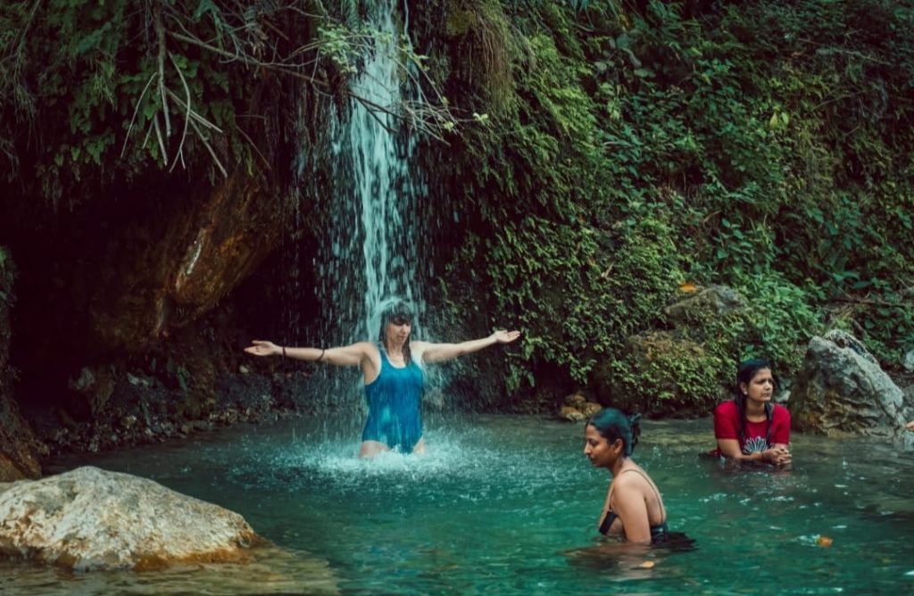 People bathing under a waterfall.