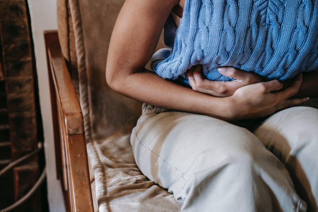 woman in blue sweater suffering period cramps